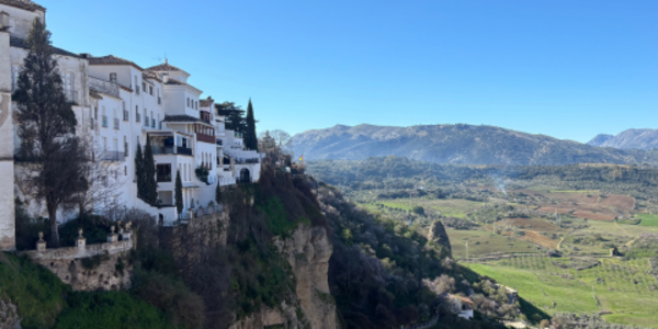 View of mountains and fields and part of the town of Ronda, Spain.