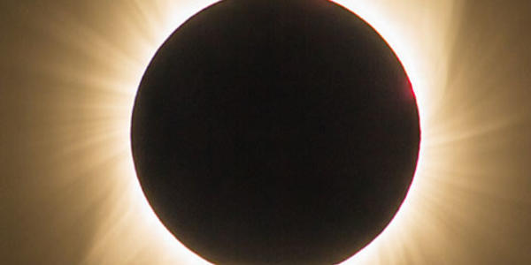 Image of a solar eclipse with a halo of light around it.
