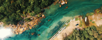 Aerial view of a river with a sandy bank on one side and a cluster of trees on the other side. Aerial view of a river with a sandy bank on one side and a cluster of trees on the other side.