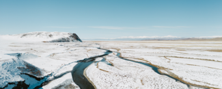 Snowy landscape with a river running through the foreground. Snowy landscape with a river running through the foreground.