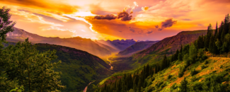 The sun setting behind clouds over a valley. The sun setting behind clouds over a valley.