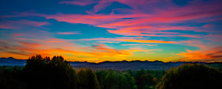 Alt text: Vibrant sunset in Asheville, NC, with bright hues of pink, yellow, and orange criss-crossing across a clear blue sky. Alt text: Vibrant sunset in Asheville, NC, with bright hues of pink, yellow, and orange criss-crossing across a clear blue sky.