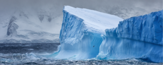 Massive iceberg floating in the Southern Ocean off Antarctica with snow-covered mountains in the background. Courtesy of GettyImages. Credit: Ray Hems. Massive iceberg floating in the Southern Ocean off Antarctica with snow-covered mountains in the background. Courtesy of GettyImages. Credit: Ray Hems.