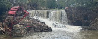 A rain-swollen Reems Creek in Weaverville, NC in the aftermath of Hurricane Helene. The remnants of a red water wheel and other debris lie along the side of the falls. A rain-swollen Reems Creek in Weaverville, NC in the aftermath of Hurricane Helene. The remnants of a red water wheel and other debris lie along the side of the falls.