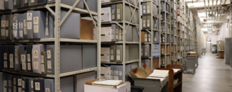 Rows of shelves stacked floor to ceiling with binders and boxes of paper environmental data records extend down a long room in the basement of NCEI headquarters in Asheville, NC. Rows of shelves stacked floor to ceiling with binders and boxes of paper environmental data records extend down a long room in the basement of NCEI headquarters in Asheville, NC.