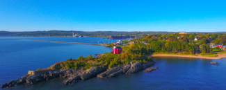 Aerial view of water on the Great Lakes and some land with trees beginning to change colors in autumn Aerial view of water on the Great Lakes and some land with trees beginning to change colors in autumn