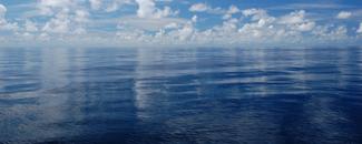 Fair weather cumulus clouds reflecting off of a glassy smooth ocean. Fair weather cumulus clouds reflecting off of a glassy smooth ocean.