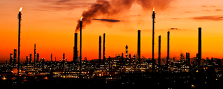 Assessing the Global Climate in July 2024 Alt Text: Smoke stacks in Spain against a red and yellow-hued sunset.