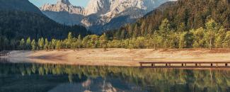 Photo of a lake with a dry shore in front of mountains Photo of a lake with a dry shore in front of mountains
