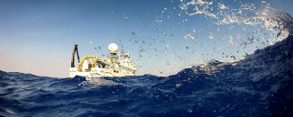 Image of Okeanos Explorer cruising on surface of ocean by NOAA. Image of Okeanos Explorer cruising on surface of ocean by NOAA.