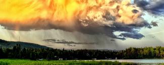 Photo of rain clouds over mountains and a lake Photo of rain clouds over mountains and a lake