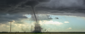 Assessing the U.S. Climate in July 2024 A tornado approaching an open field with a tinge of blue sky in the background.